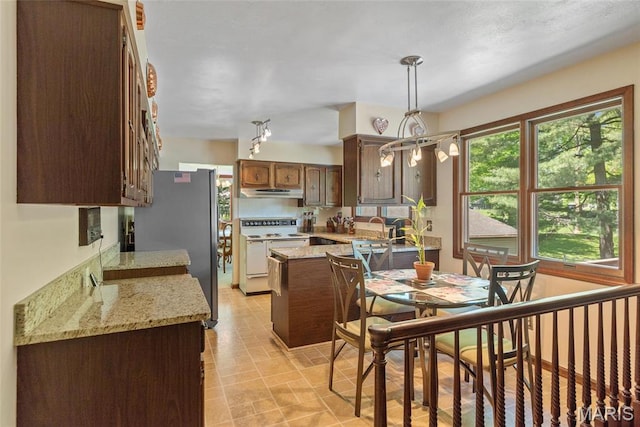 1934 Brigantine Cir, Worden, IL 62097 - kitchen featuring electric stove, freestanding refrigerator, under cabinet range hood, a peninsula, and hanging light fixtures