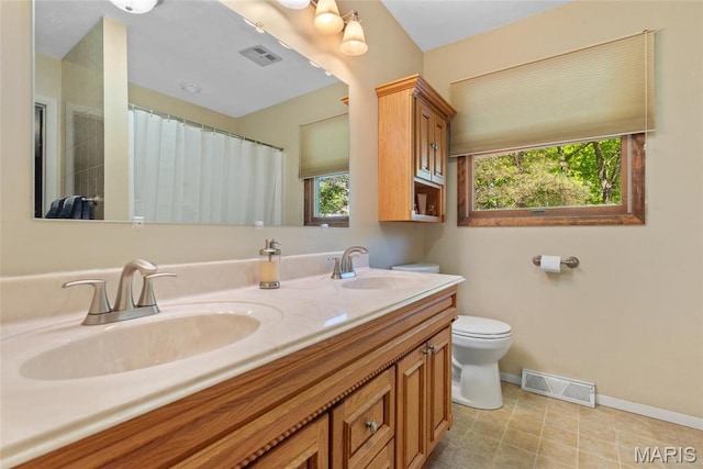 1934 Brigantine Cir, Worden, IL 62097 - bathroom featuring plenty of natural light, toilet, double vanity, and baseboards