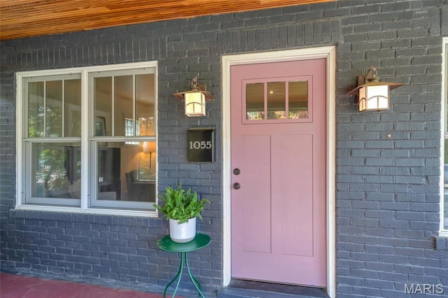 view of exterior entry with brick siding