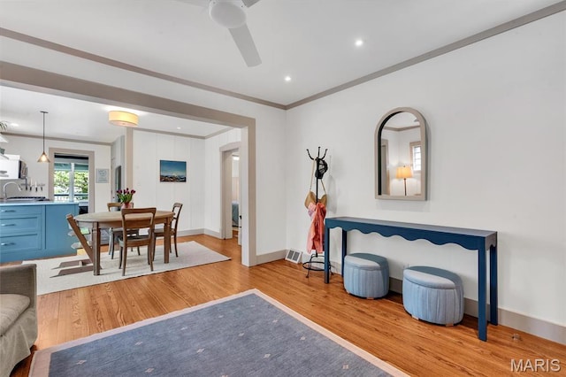dining area featuring wood finished floors, ornamental molding, a ceiling fan, baseboards, and recessed lighting