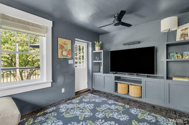 living area with healthy amount of natural light and a ceiling fan