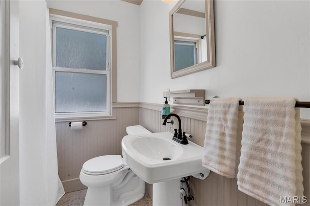 bathroom featuring wainscoting and toilet