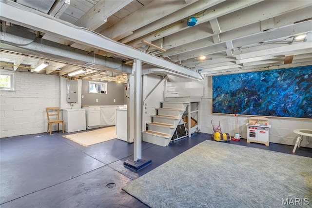 basement with separate washer and dryer, electric panel, stairway, and concrete block wall