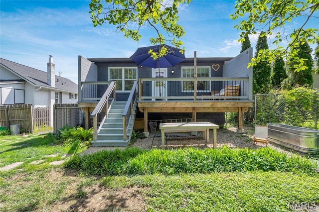 rear view of property featuring stairs, fence, and a deck