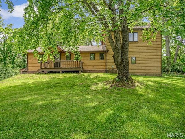 back of property featuring a wooden deck and a yard