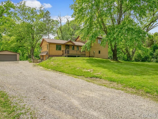 view of front of house featuring an outdoor structure, a front lawn, and a detached garage