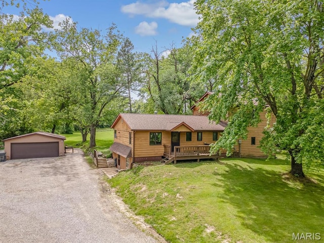 view of front of house featuring an outbuilding, a garage, a front yard, and a wooden deck
