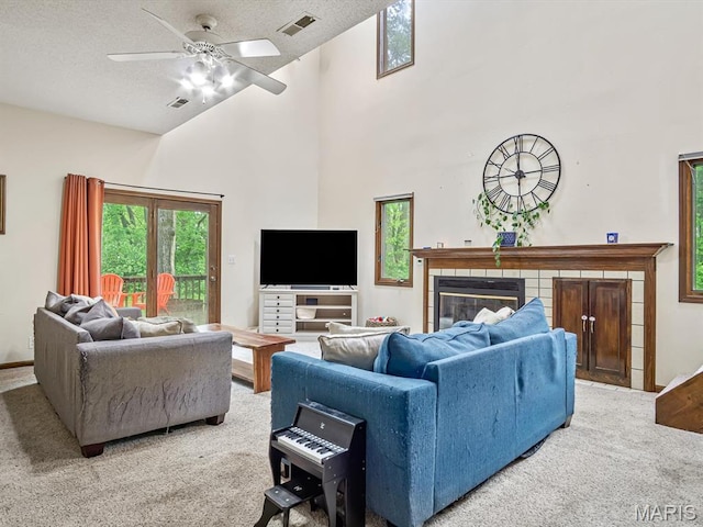 living area with carpet, high vaulted ceiling, a ceiling fan, a fireplace, and a textured ceiling