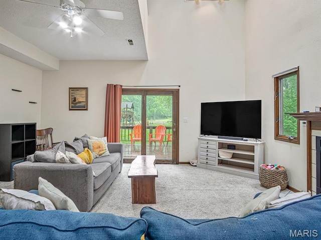 living room featuring carpet floors, a ceiling fan, and a towering ceiling