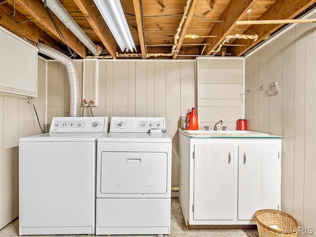 washroom featuring washer and clothes dryer and wood walls