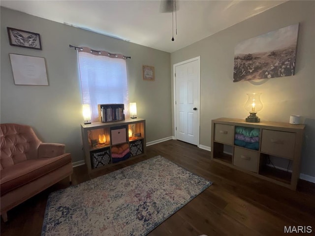 sitting room featuring dark wood-type flooring and baseboards