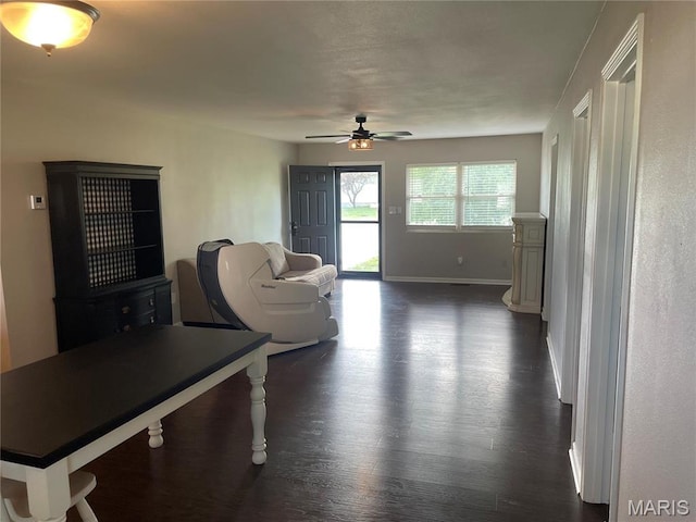 living room with ceiling fan, dark wood-style floors, and baseboards