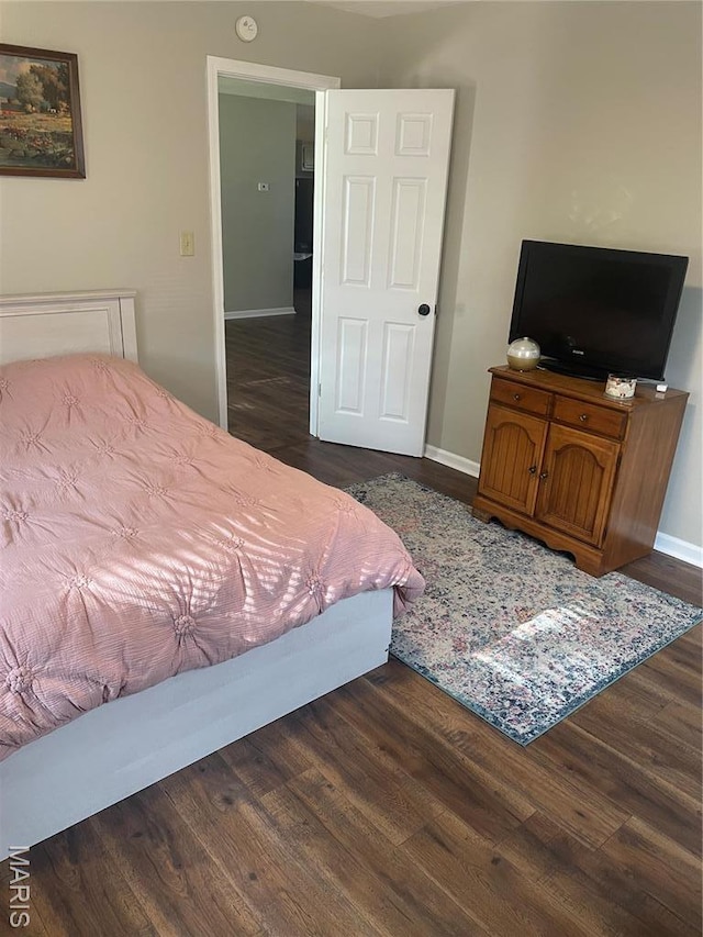 bedroom featuring dark wood-style flooring and baseboards