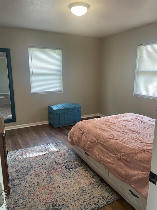 bedroom with wood finished floors and baseboards