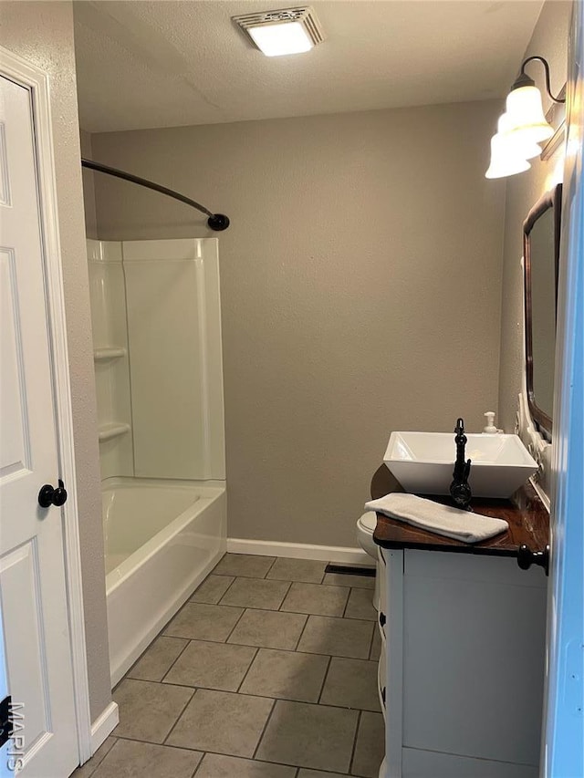 bathroom featuring tile patterned flooring, vanity, toilet, washtub / shower combination, and baseboards
