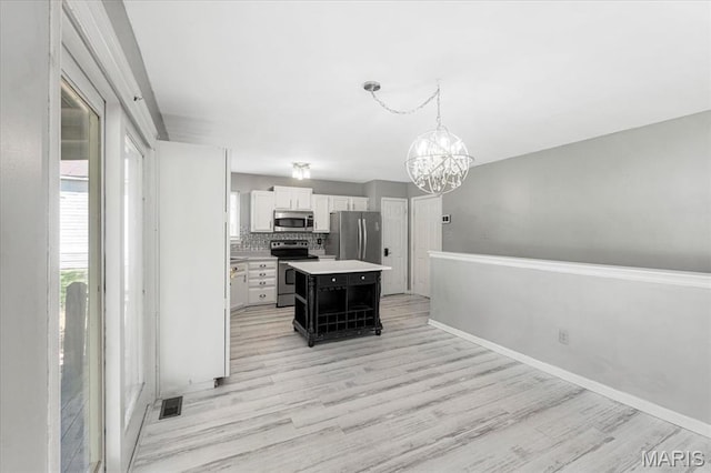 667 Workman Rd, Eureka, MO 63025 - kitchen featuring appliances with stainless steel finishes, light wood-style flooring, a chandelier, and white cabinetry