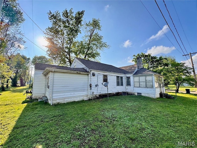 back of property with a lawn and a chimney