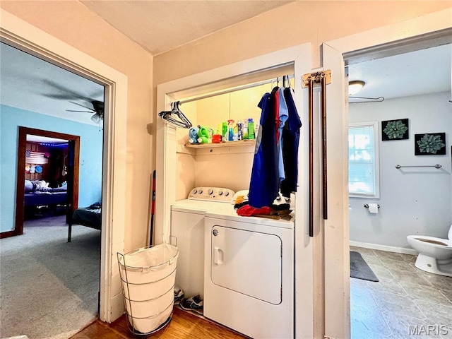 laundry room featuring washing machine and dryer, a ceiling fan, and baseboards