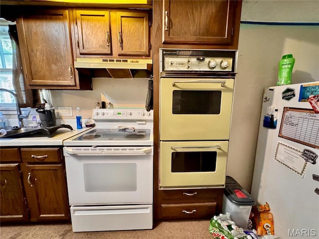 kitchen with fridge, white electric range oven, double oven, under cabinet range hood, and light countertops