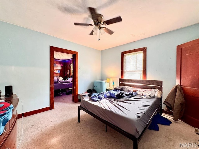 carpeted bedroom with ceiling fan and baseboards
