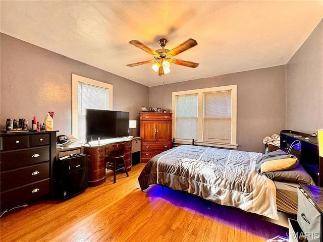bedroom with light wood-style flooring and a ceiling fan