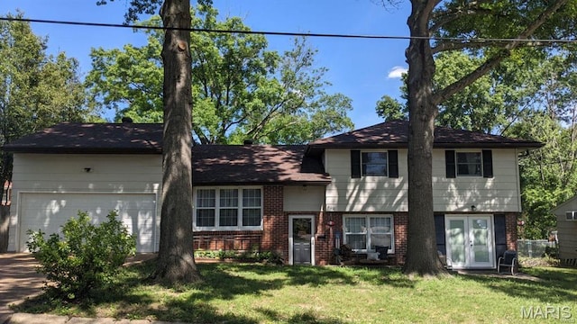 tri-level home with brick siding, an attached garage, a front yard, and concrete driveway