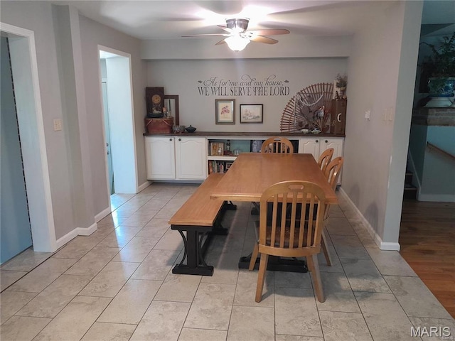 dining room with a ceiling fan and baseboards
