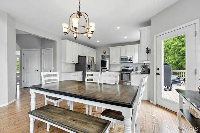 dining room with a chandelier, light wood-type flooring, recessed lighting, and baseboards