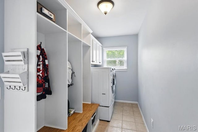 laundry room with cabinet space, washer and dryer, baseboards, and light tile patterned floors