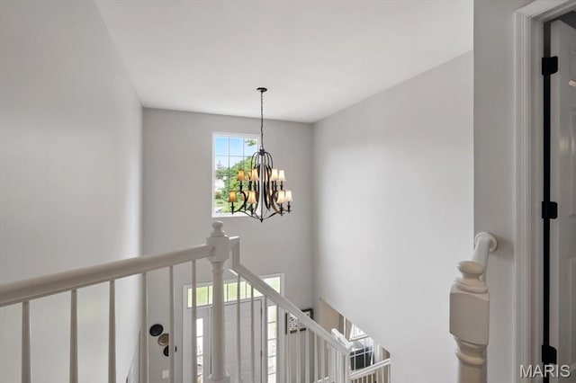 stairs featuring a chandelier