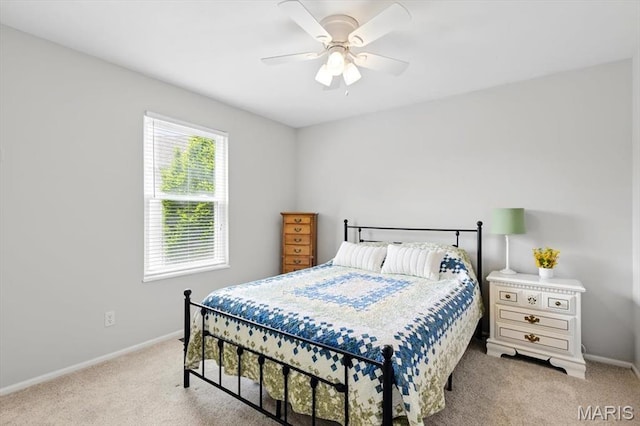 bedroom with light carpet, baseboards, and a ceiling fan