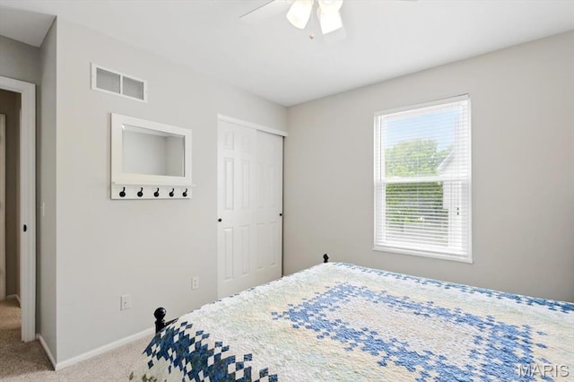 bedroom with carpet flooring, a closet, baseboards, and a ceiling fan