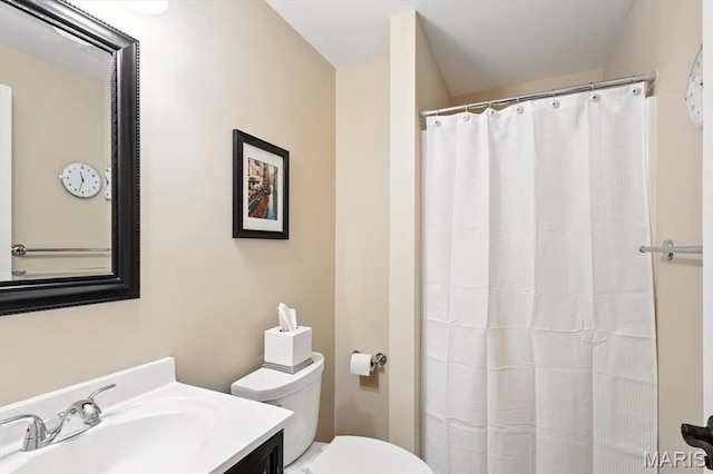 full bath featuring toilet, vanity, and curtained shower