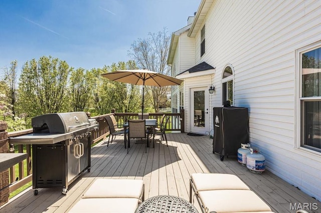 wooden terrace with outdoor dining area and a grill
