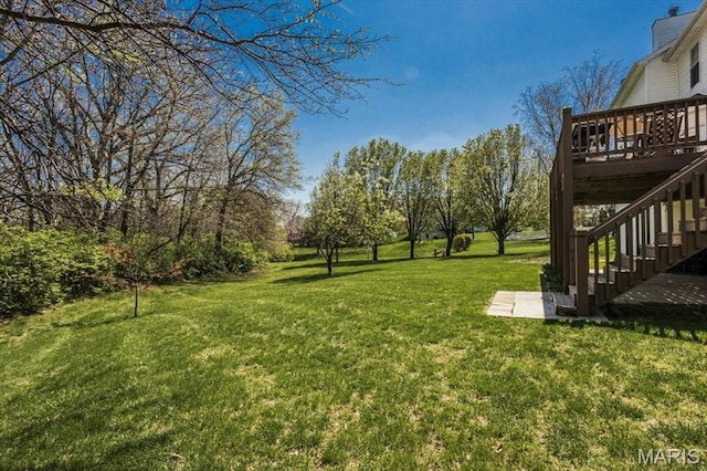 view of grassy yard with a deck and stairway