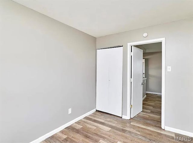 1749 Foley Dr, Saint Louis, MO 63136 - unfurnished bedroom with wood finished floors, baseboards, and a closet