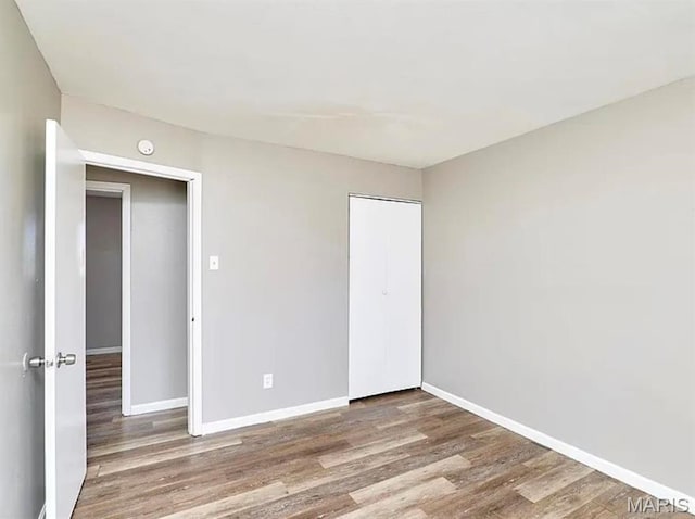 1749 Foley Dr, Saint Louis, MO 63136 - unfurnished bedroom featuring wood finished floors, baseboards, and a closet