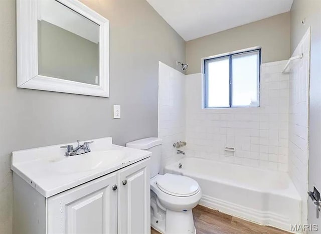 1749 Foley Dr, Saint Louis, MO 63136 - bathroom with toilet, vanity, washtub / shower combination, and wood finished floors