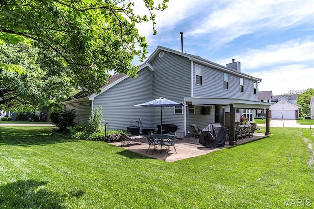 back of property featuring a chimney, a lawn, and a patio