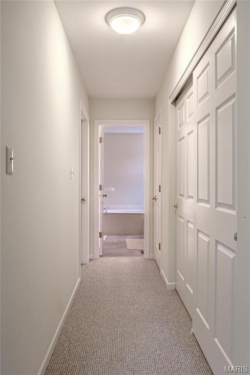 corridor with light colored carpet and baseboards