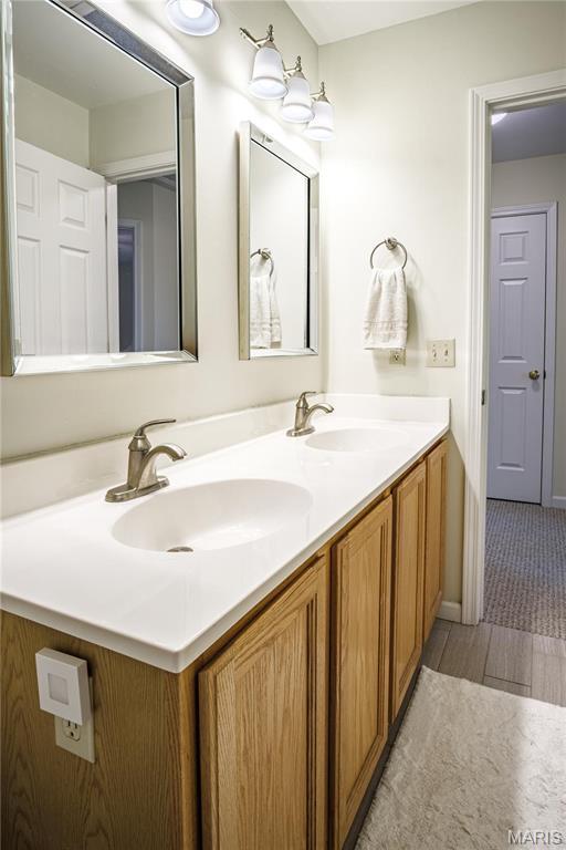 bathroom with double vanity and wood finished floors