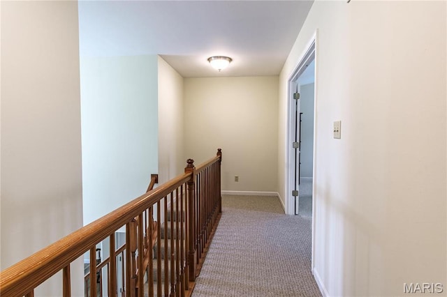 hallway featuring an upstairs landing, carpet, and baseboards