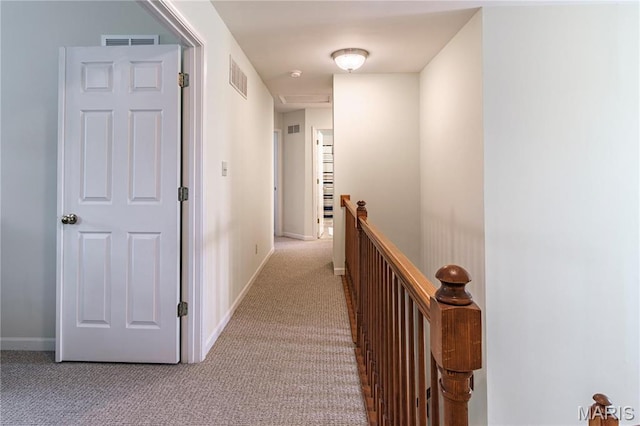 hallway featuring an upstairs landing, light colored carpet, and baseboards