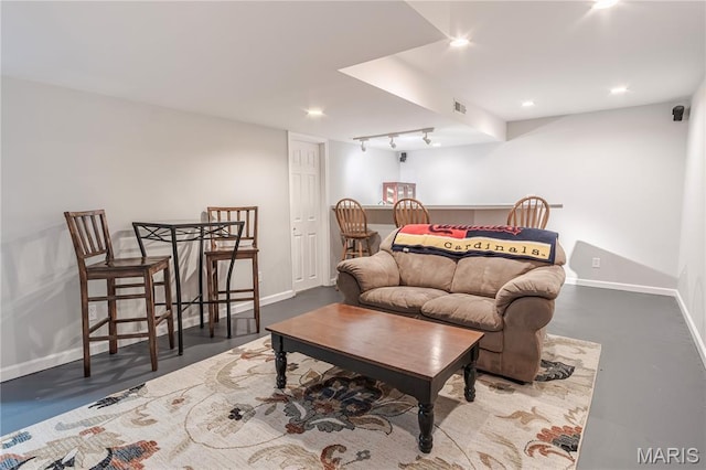 living area featuring baseboards, concrete floors, recessed lighting, and rail lighting
