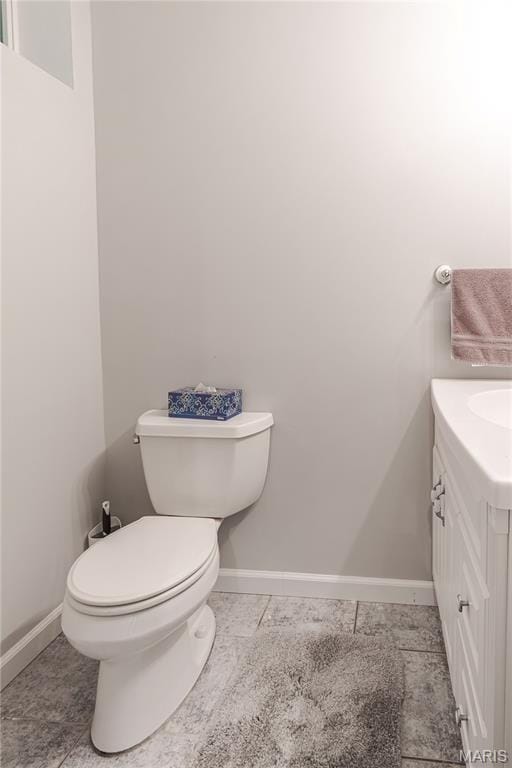 bathroom featuring baseboards, toilet, vanity, and tile patterned flooring
