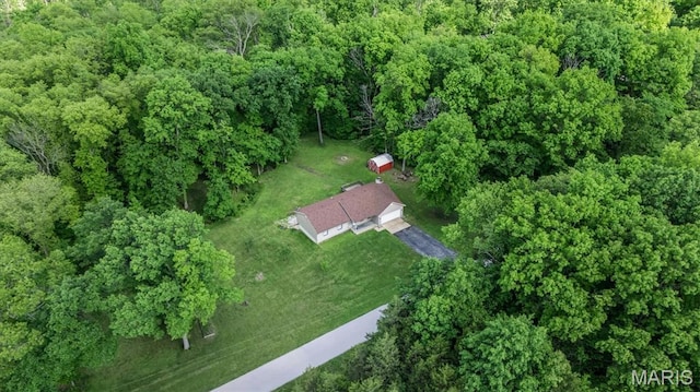 aerial view of property and surrounding area with a heavily wooded area