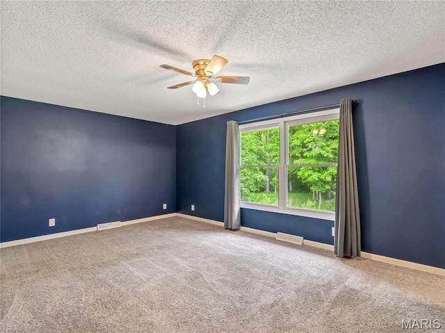 spare room featuring ceiling fan, carpet floors, a textured ceiling, and baseboards