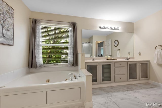 7302 Macleod Ln, Ofallon, MO 63368 - bathroom with healthy amount of natural light, marble finish floors, a jetted tub, and double vanity