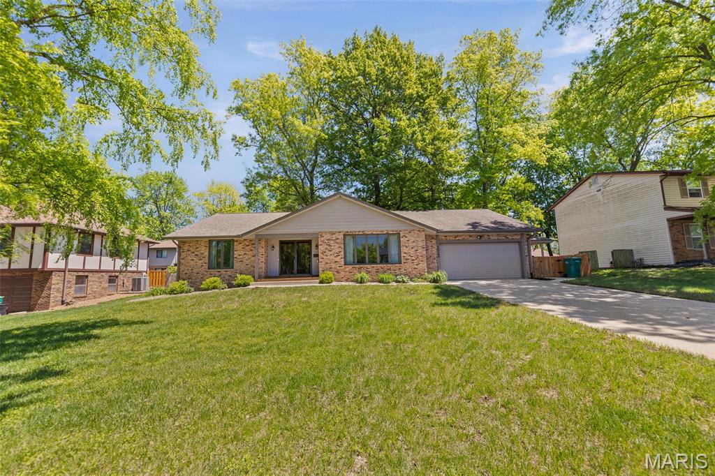 1012 Matthew Dr, Ofallon, IL 62269 - view of front of property featuring an attached garage, concrete driveway, brick siding, and cooling unit
