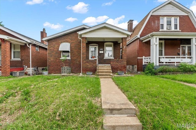 view of front of house with a porch, a front yard, brick siding, and cooling unit
